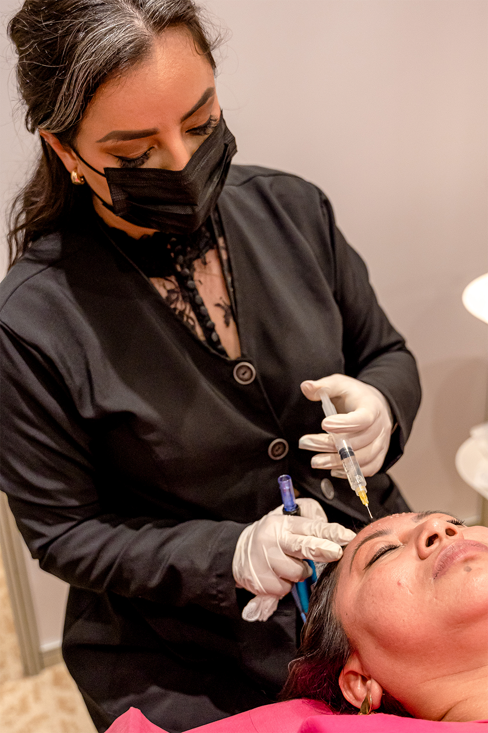 Profesional de la salud aplicando un tratamiento facial con jeringa en un taller práctico de CIMEC 2023.