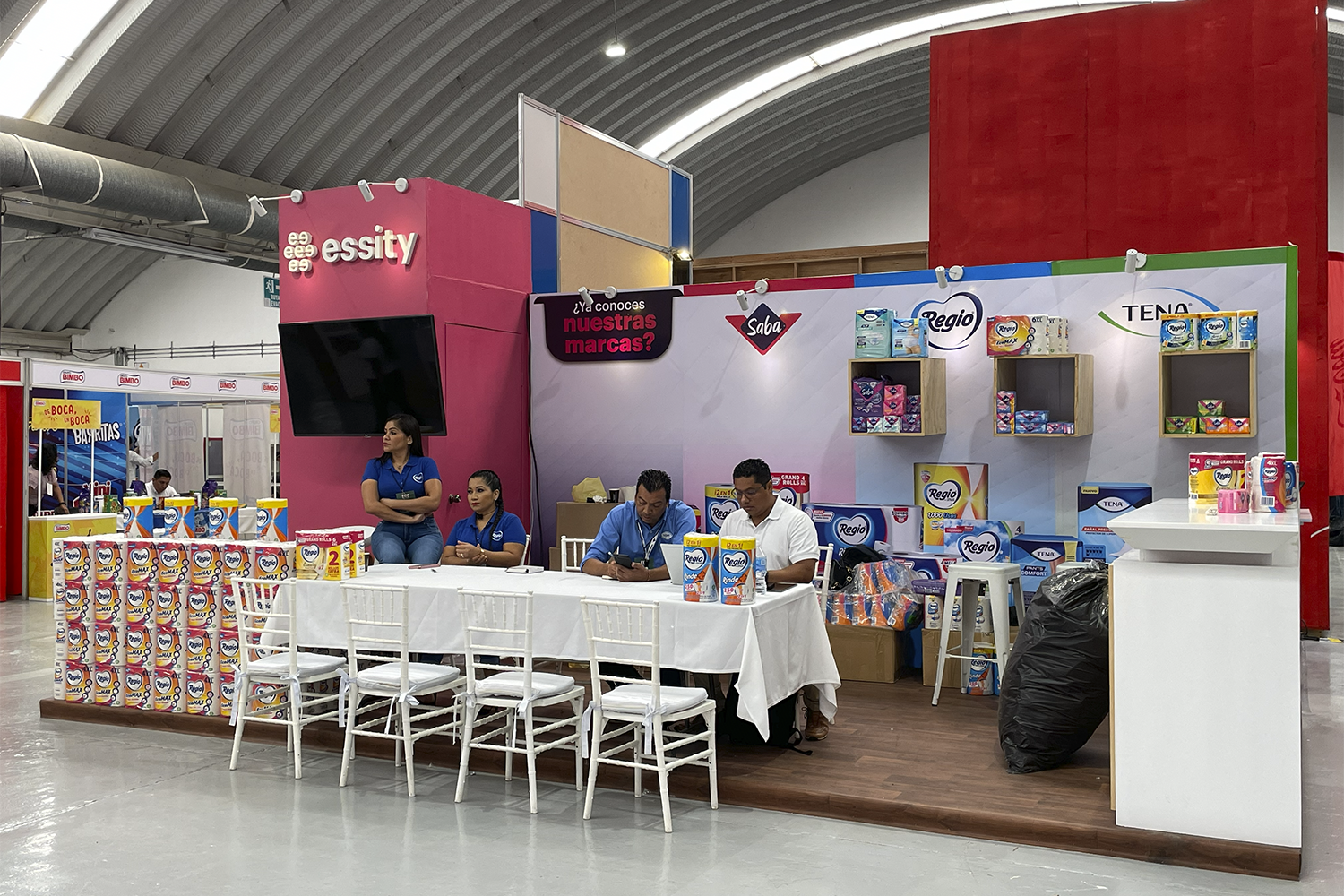 Expo Sánchez 2023: stand con tarima de madera y área de mesas para atención