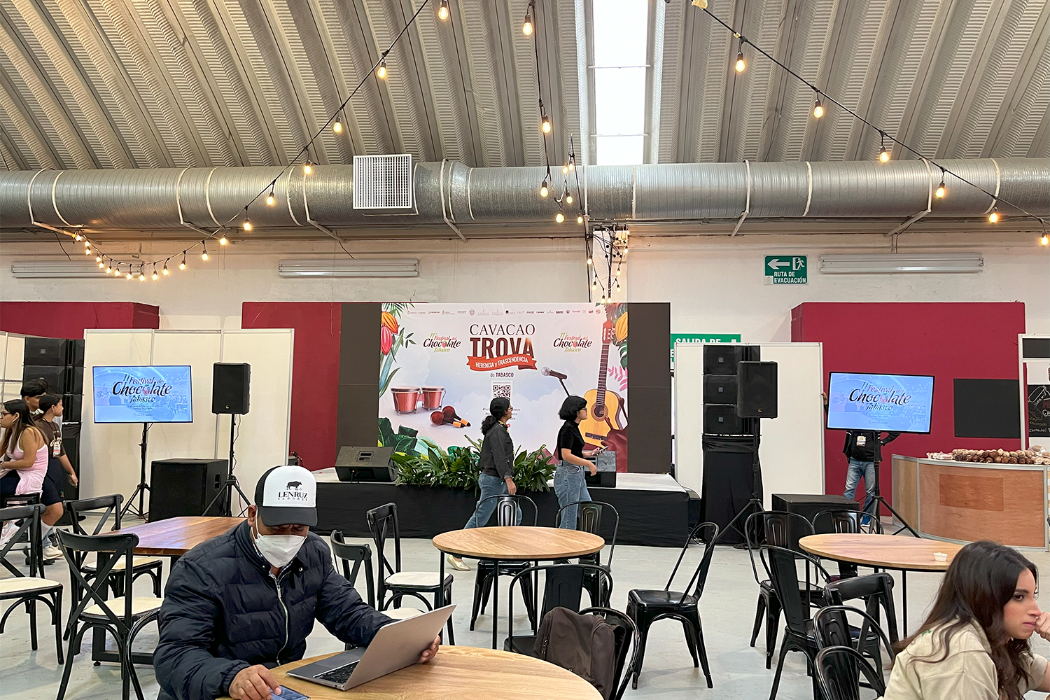 Área de comedor y descanso con escenario para 'Cavacao Trova' en el festival.