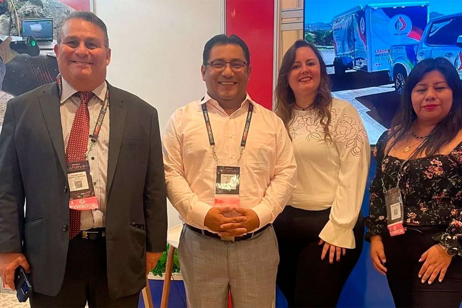 Asistentes y expositores posando en un stand del área comercial de IMCORRS 2023.