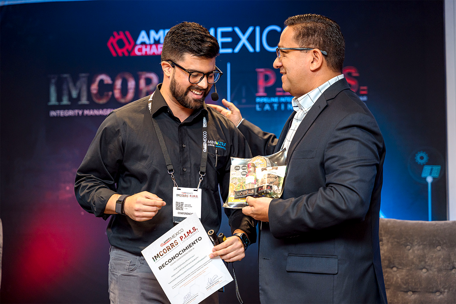 Entrega de reconocimiento a un ponente en el escenario de IMCORRS 2024.