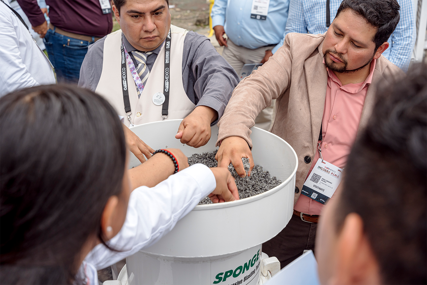 Asistentes participando activamente en una demostración de materiales abrasivos.